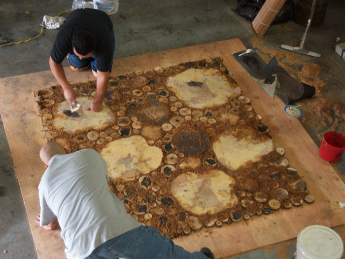 Filling gaps with resin sawdust mixture to create burl floor.