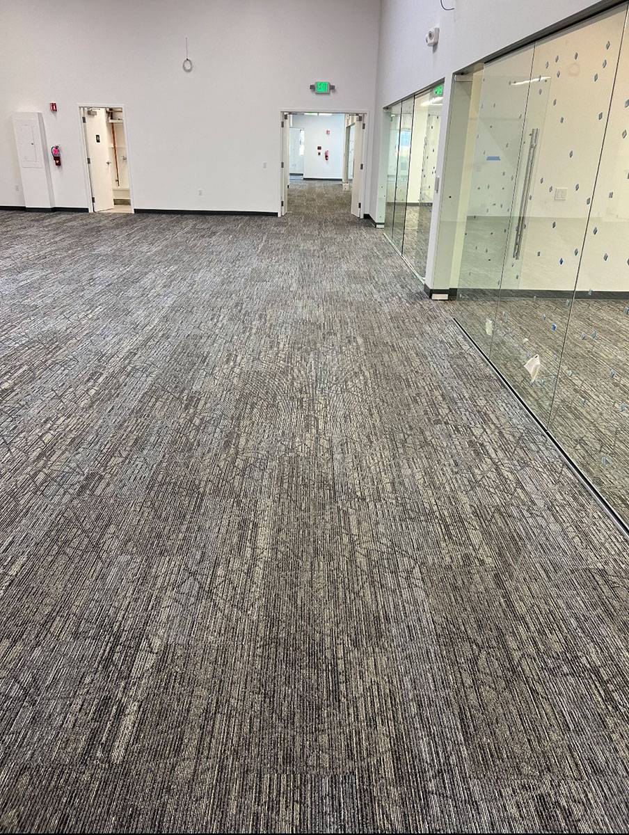 Rooms and hallways of a large office building with brand new gray carpet flooring installed by Slaughterbeck Floors.