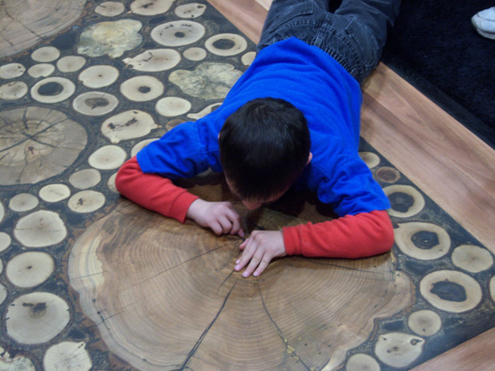 Putting the finishing touches on custom made burl floor.