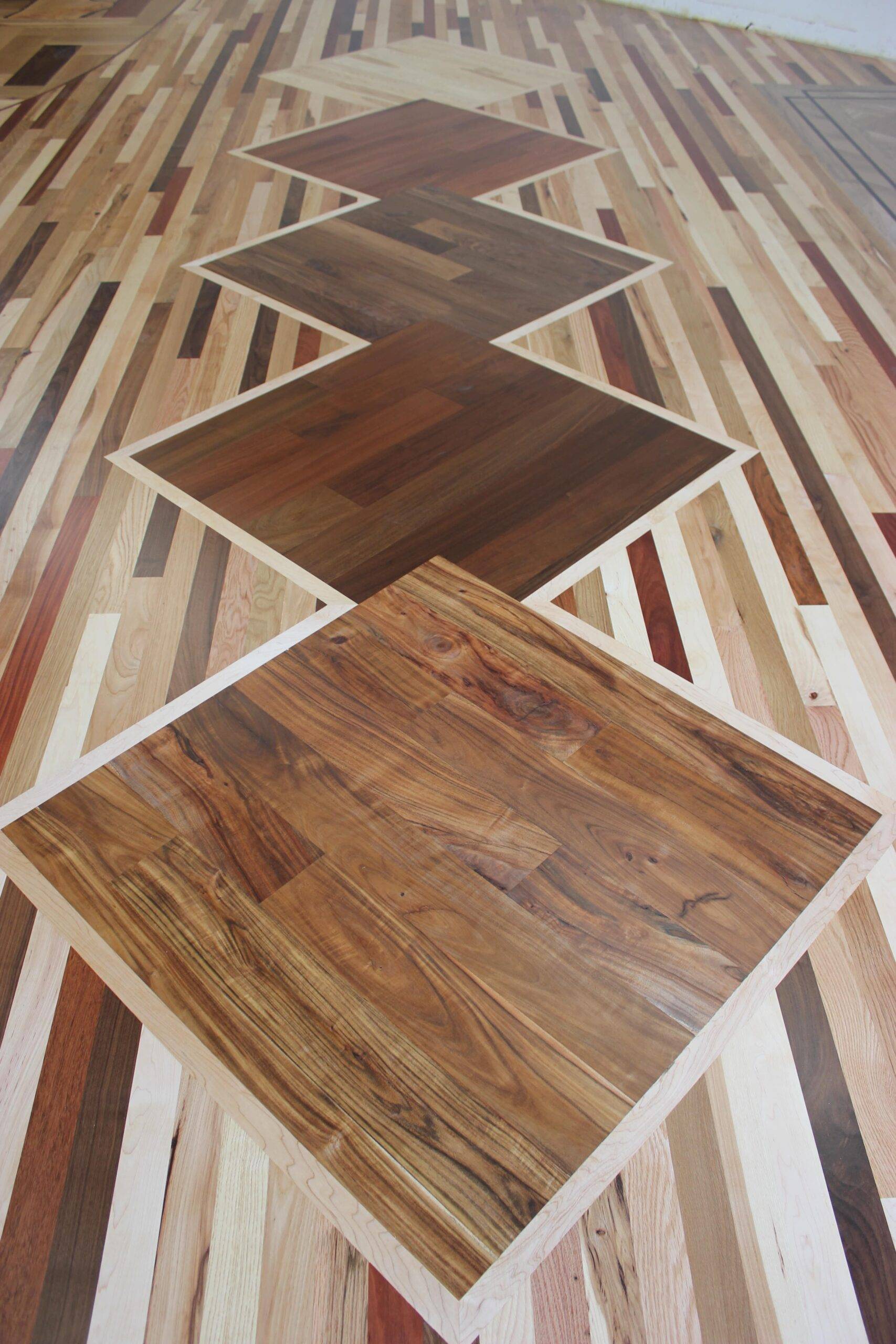 Closeup of remodeled showroom floor’s custom hardwood diamond pattern inlay.