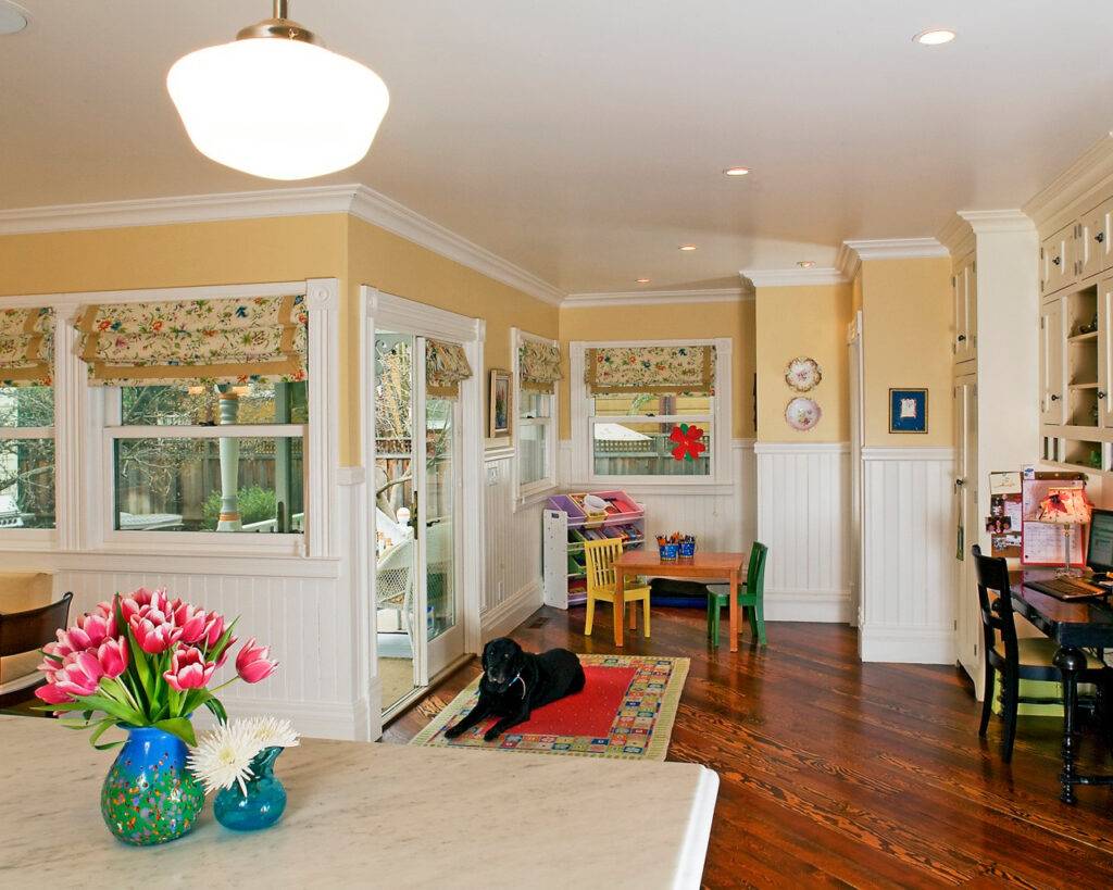 Pet-friendly hardwood flooring with protective mats near entryways and a dog lounging on a throw rug showcasing preventive care steps for protecting floors.